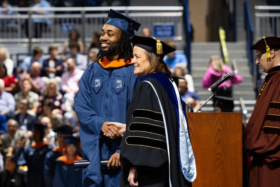 Rice Provost Amy Dittmar congratulates a male graduate.