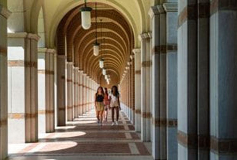 Students walking underneath Rice archway. 