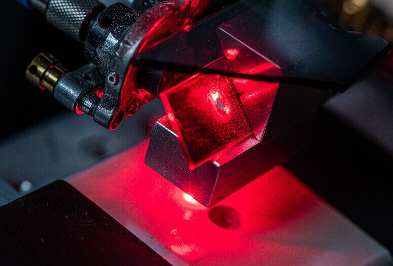 A Rice University lab tests material covered in strain-sensing smart skin. The multilayer coating contains carbon nanotubes that fluoresce when under strain, matching the strain experienced by the material underneath. (Credit: Jeff Fitlow/Rice University) 