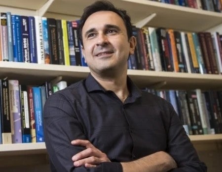 Flavio Cunha in front of his bookcase