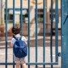 Child standing at schoolyard gate