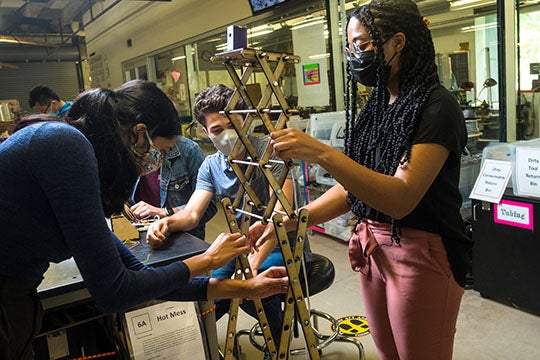 Rice University engineering students have designed a low-cost touchless temperature monitor for use during the COVID-19 pandemic and beyond. Here, Sanjana Krishnan, left, and Kyla Barnwell adjust the prototype lift device that holds the infrared sensor at the proper height. (Credit: Photo by Jeff Fitlow/Rice University)