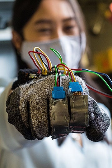 Rice University graduate student Linda Liu models the prototype glove to help reward the positive behaviors of people with trichotillomania, the compulsive pulling of hair. Photo by Jeff Fitlow