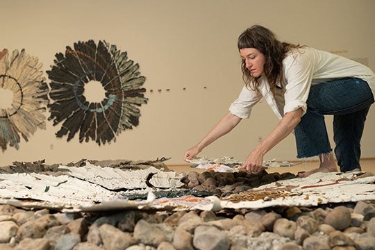 Ruais places part of an abstract ceramic sculpture atop an earthen mound inside the Moody's Central Gallery.