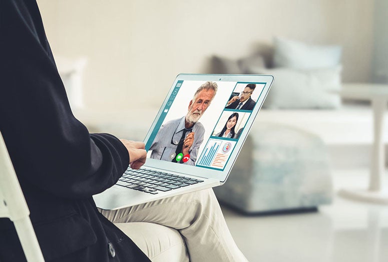 Person sitting on zoom meeting with computer on lap