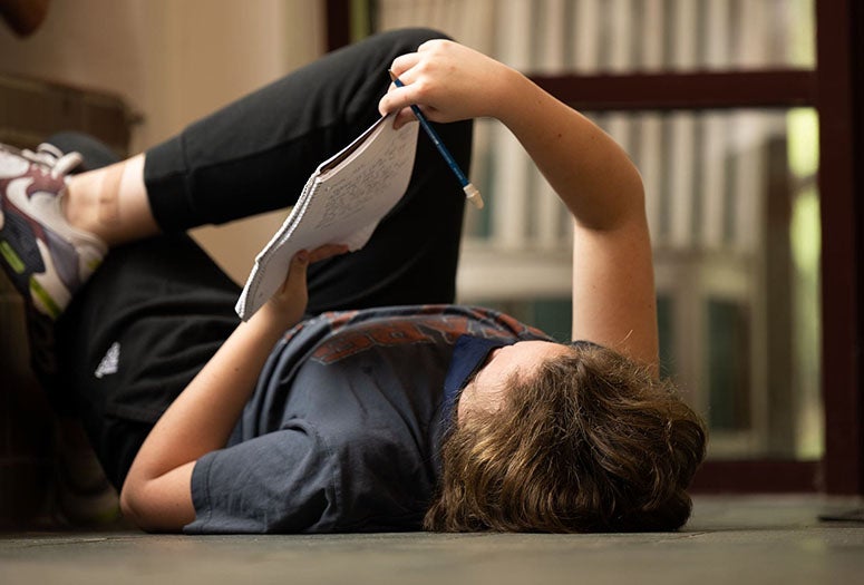 Student lying with book. 