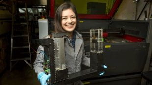 Cofer holds the 3D graphene printer she built in James Tour’s lab.