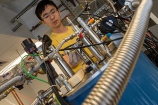 Former Rice University graduate student Xinwei Li in 2016 with the terahertz spectrometer he later used to measure entanglement in the conduction electrons flowing through a "strange metal" compound of ytterbium, rhodium and silicon. (Photo by Jeff Fitlow/Rice University)