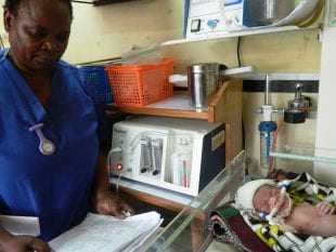 Neonatal nurse Florence Mwenifumbo monitors a newborn that is receiving bubble CPAP treatment at Queen Elizabeth Central Hospital in Blantyre, Malawi. (Photo courtesy of Rice 360°/Rice University)