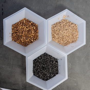 Rice researchers used a trio of soil amendments to test the process by which plants communicate with microbes to obtain nutrients and ward off pests. Clockwise from top left are mesquite chips, maple chips and charcoal made from maple chips. Photo by Jeff Fitlow
