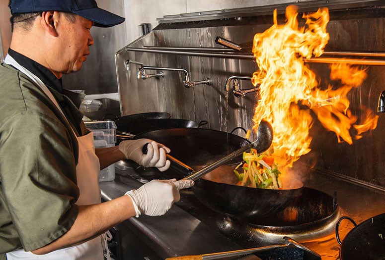 Andy Tat fires up lunch at Wok on Sunset in the North Servery. (Photos by Tommy LaVergne)