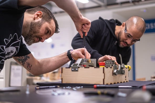 Danny Blacker, left, and Fernando Cruz, staffers at Rice University’s Oshman Engineering Design Kitchen, assemble a prototype of the ApolloBVM bag valve mask automation device. Photo by Jeff Fitlow