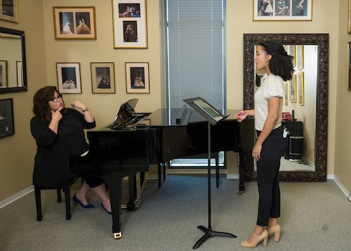Kanisha Feliciano training with instructor on a piano