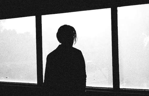 Photo of teen looking out the window.