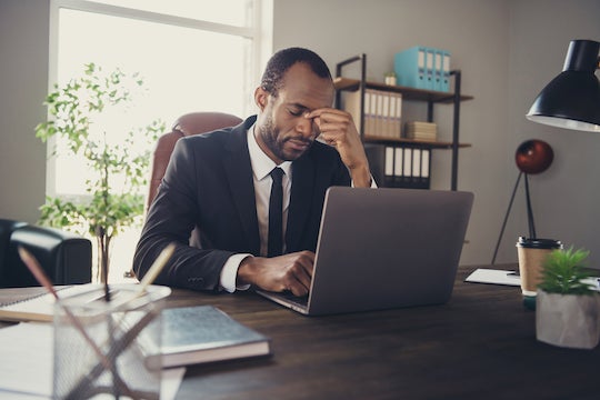 Black employee at desk.