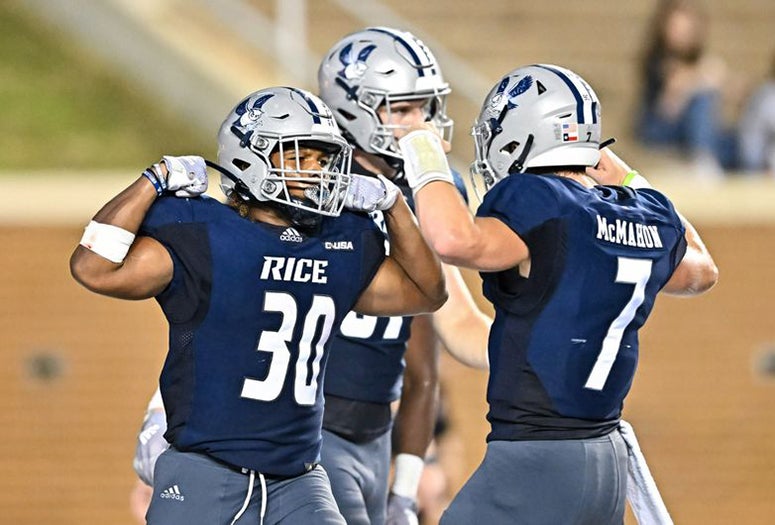 Rice football players flex while celebrating during a victory over Louisiana at Rice Stadium.
