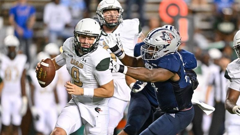 The UAB quarterback is pursued by a Rice defender in their football game Oct. 1 at Rice Stadium.