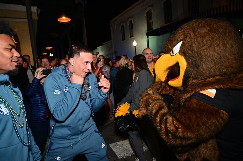 A Rice football player playfully squares up the Southern Miss mascot ahead of the Owls' 2022 LendingTree Bowl appearance in Mobile, Alabama.