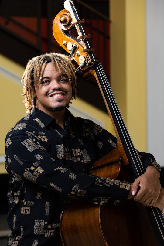 Photo of Christian Harvey standing with his double bass.