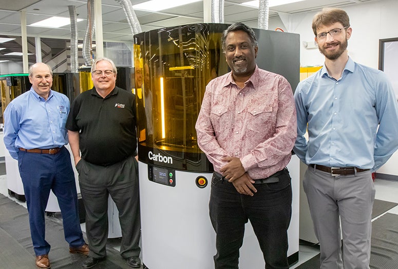 From left, Andrew Cooper and Rick Jennings of TyRex Group join Rice's Paul Cherukuri and Grant Belton for a photo with Rice's L1 3D printer, which is located at TyRex's manufacturing plant in Austin, Texas