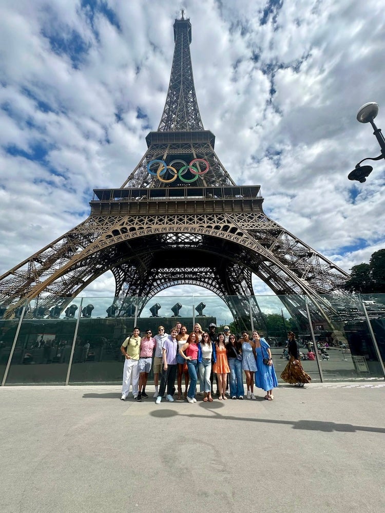 Rice sport management students posing underneath the Eiffel Tower in Paris.