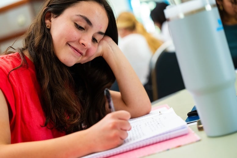 Creative Writing Camp student writes in June 2024.