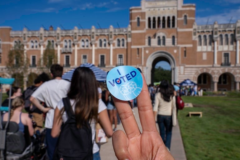 Rice "I voted" sticker with Lovett Hall in the background. 
