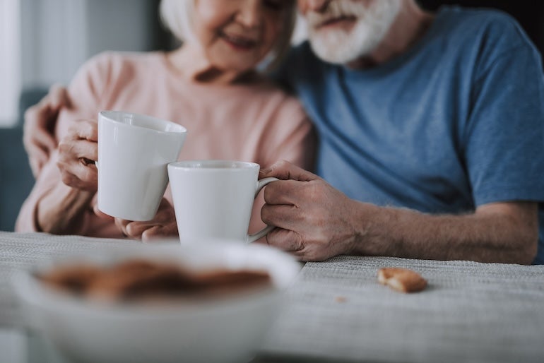 Elderly spouses having coffee