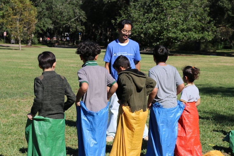 Refugee children enjoy a potato sack race at the Rice fall festival.