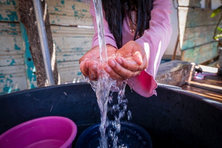 Stock photo of girl washing hands in water stream