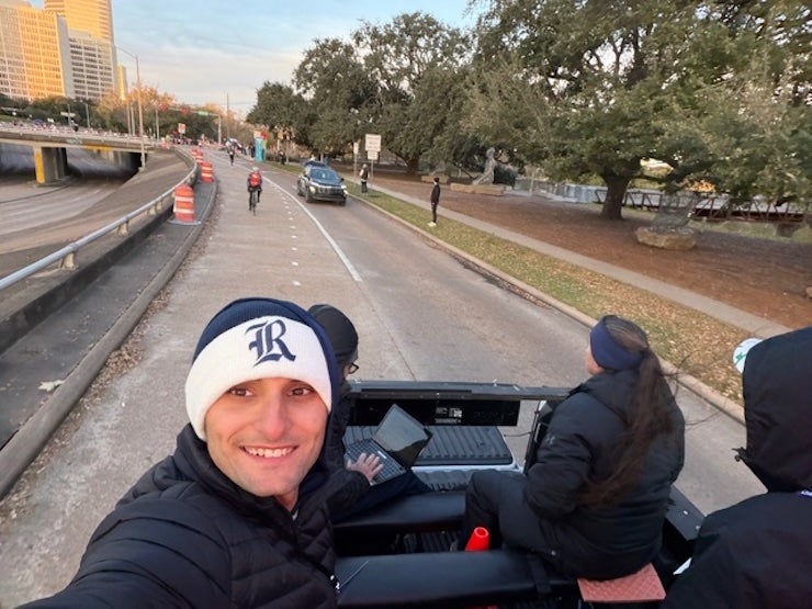Rice student Jackson Moran riding on pace vehicle. 