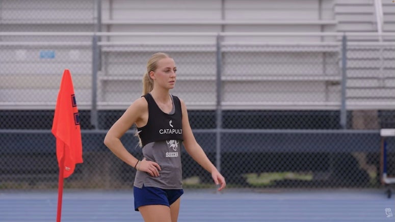 A Rice women's soccer player wears a tracker vest at practice.