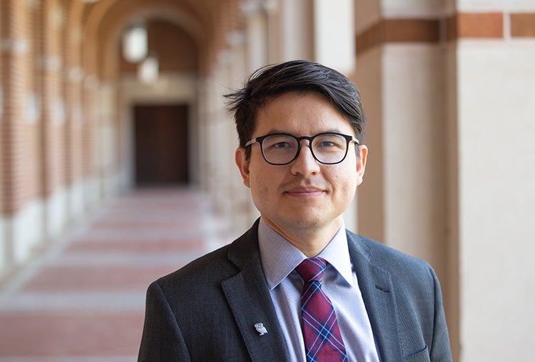 landscape orientation photo of man wearing a suit and tie looking at the camera