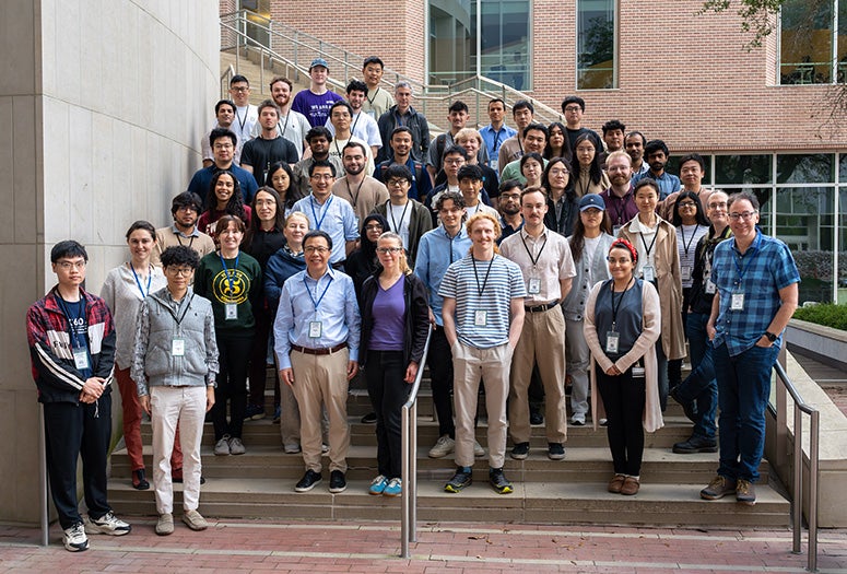 A group of people stand on an outdoor stairwell. 