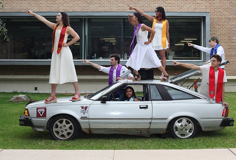 students posing with car