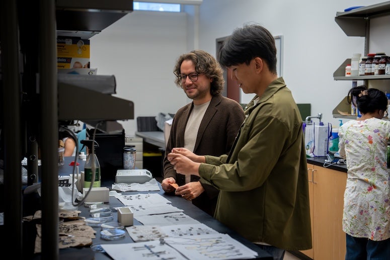 Two researchers working at the lab bench and talking.