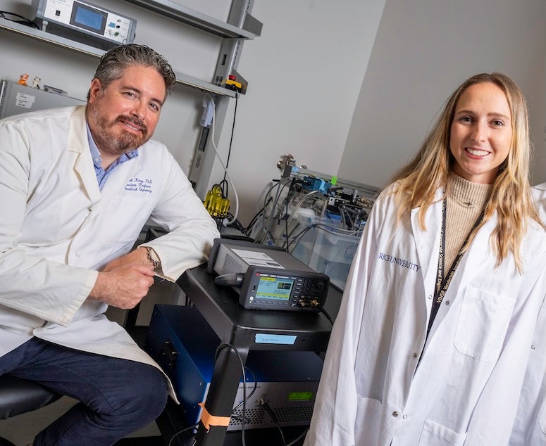 A man and a woman are in a lab and wearing lab coats. 