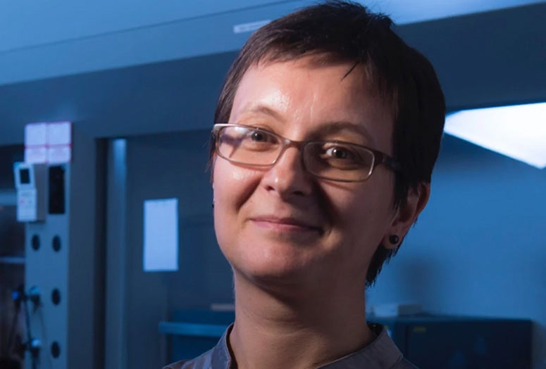 A white woman smiles at the camera