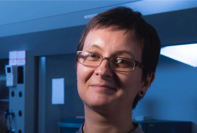A white woman smiles at the camera