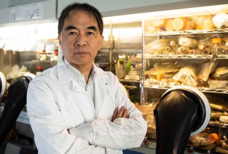 An Asian man in a lab looks at the camera