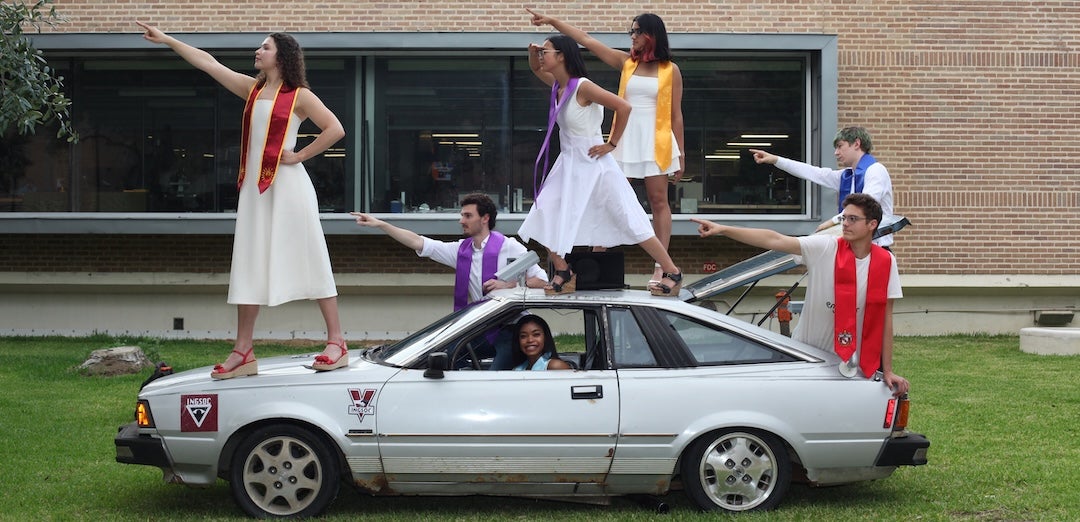 students posing with a car 