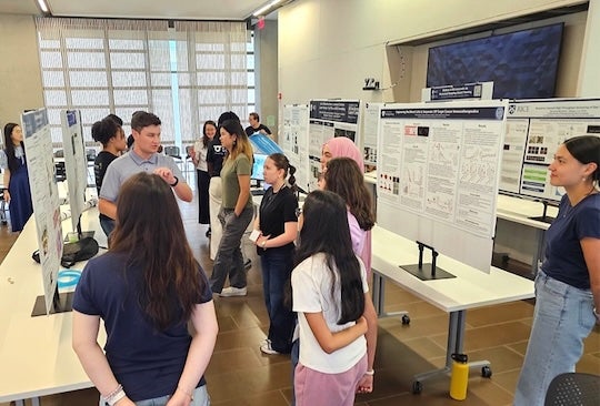students listening to presentation during poster session