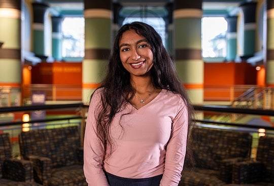 young woman in pink shirt looking at the camera smiling