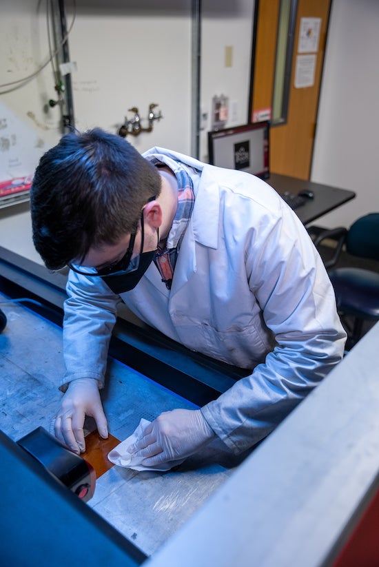 Alex Lathem, an applied physics graduate student at Rice, prepares a sample for lasing. The lab is using sound to analyze the synthesis of laser-induced graphene in real time. Photo by Brandon Martin