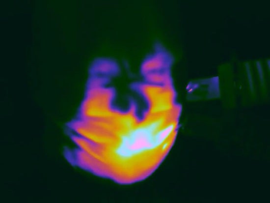 An infrared image shows hot air supplied to a mannequin by a hair dryer leaking from around the nose and on the side of a standard surgical mask. Rice University engineers designed a silicone harness that stopped the leaks. (Credit: Robinson Lab/Rice University)