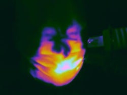 An infrared image shows hot air supplied to a mannequin by a hair dryer leaking from around the nose and on the side of a standard surgical mask. Rice University engineers designed a silicone harness that stopped the leaks. 