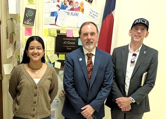 one woman and two men posing for the camera
