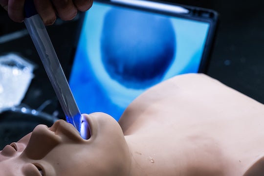 The laryngoscope built by Rice University students aided by a Houston anesthesiologist allows clinicians to track the progress of an intubation through a wireless device like a tablet, seen in the background. 