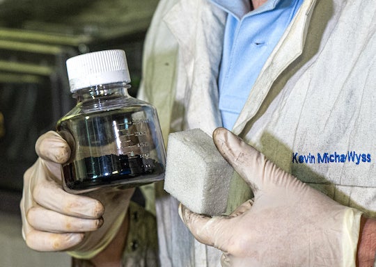 Rice University graduate student Kevin Wyss holds a vial of graphene and samples of the graphene-reinforced polyurethane made by the Ford Motor Company. Ford collaborated with a Rice lab to recycle plastic from end-of-life vehicles into graphene through flash Joule heating, then used that graphene in new foam. (Credit: Jeff Fitlow/Rice University)