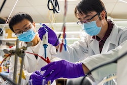 Postdoctoral fellow Zhen-Yu Wu, left, and graduate student Feng-Yang Chen set up an experiment at their Rice University laboratory to extract ammonia and solid ammonia -- aka fertilizer -- from a wastewater model with low levels of nitrate. (Credit: Jeff Fitlow/Rice University)